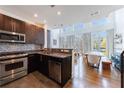 Modern kitchen with stainless steel appliances, mosaic backsplash, and open layout to living area at 1221 Caroline Ne St # 201, Atlanta, GA 30307