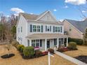 Two-story home featuring blue shutters, covered front porch with seating, and a well-maintained yard at 300 South Village Sq, Canton, GA 30115