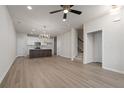 Open-concept living area features a modern kitchen, stairs, and beautiful light fixture at 58 Black Gum Ln # 47, Auburn, GA 30011