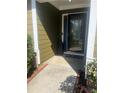 A welcoming front entrance with a glass paneled door, brick trim, and a manicured garden at 8236 Eastshore Dr, Union City, GA 30291