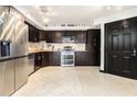 A modern kitchen features stainless steel appliances, dark cabinets, and sleek tile flooring at 795 Hammond 1013 Dr, Sandy Springs, GA 30328