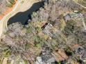 Bird's eye view of the brick home surrounded by trees, near a pond, and other houses at 812 Burning Tree Se Ct, Marietta, GA 30067