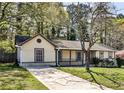 Charming single-story home with a well-manicured lawn, a covered front porch, and mature trees at 3427 Springlake Dr, Decatur, GA 30032