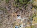 Overhead view of the house with a long driveway, surrounded by lush trees and natural landscape at 138 Rutledge Rd, Temple, GA 30179