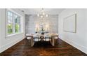 Charming dining room with hardwood floors, a brick accent wall, and a large window at 5805 Clarion St., Cumming, GA 30040
