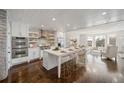 Modern kitchen featuring a spacious island, white cabinetry, stainless steel appliances, and hardwood flooring at 5805 Clarion St., Cumming, GA 30040