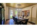 Formal dining room features wainscoting, chandelier, and views of the front yard at 2698 Bonar Hall Path, Duluth, GA 30097