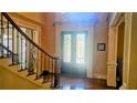 Grand foyer featuring hardwood floors, decorative front door, and elegant staircase with wrought iron details at 2698 Bonar Hall Path, Duluth, GA 30097