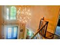 Bright, two-story foyer with decorative chandelier, large windows, and decorative front door at 2698 Bonar Hall Path, Duluth, GA 30097