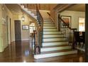 Elegant foyer with curved staircase featuring wrought iron spindles and beautiful hardwood flooring at 2698 Bonar Hall Path, Duluth, GA 30097