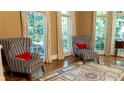 Sun-filled living room with wingback chairs, striped pattern and large windows at 2698 Bonar Hall Path, Duluth, GA 30097