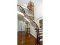 Elegant foyer staircase featuring a decorative chandelier and hardwood floors at 2698 Bonar Hall Path, Duluth, GA 30097