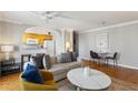 Bright living room featuring hardwood floors, neutral walls, ceiling fan, dining area, and kitchen access at 300 Peachtree Ne St # 19B, Atlanta, GA 30308