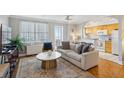 Open concept living room with hardwood floors, neutral walls, ceiling fan, balcony, and kitchen access at 300 Peachtree Ne St # 19B, Atlanta, GA 30308