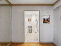 Hallway view with a glimpse into the well-lit, modern kitchen, featuring white cabinetry at 300 Peachtree Ne St # 18I, Atlanta, GA 30308