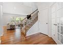 Open living room with hardwood floors, staircase, and french doors leading to another room at 3505 Aqua Point Pl, Cumming, GA 30041