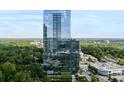 Modern high-rise building featuring glass facade and lush surrounding landscape at 3630 Peachtree Ne Rd # 2009, Atlanta, GA 30326