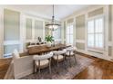 Bright dining room featuring a large wooden table, stylish chandelier and panel molding at 305 Inman Pl, Roswell, GA 30075