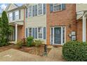 Close up of the townhome's front entrance, featuring a beautiful door, brick facade, and lovely landscaping at 345 Timber Gate Court, Lawrenceville, GA 30045