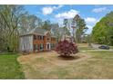 Brick front home showcasing a well-manicured lawn and mature trees surrounding the property at 4495 Sagebrush Nw Dr, Kennesaw, GA 30152