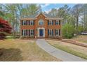 Two-story brick home with a landscaped front yard and charming walkway to the entrance at 4495 Sagebrush Nw Dr, Kennesaw, GA 30152