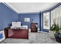 Office with a large desk, comfortable carpet, and bright natural light from the many windows at 269 Hidden Wood Ct, Lawrenceville, GA 30043