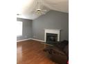 Living room featuring a fireplace, high ceilings, hardwood floors, and a ceiling fan with light at 4528 Baker Grove Nw Rd, Acworth, GA 30101