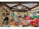 Living room features stone fireplace, beamed ceilings, hardwood floors and ornate area rug at 1050 E Club Ne Ln, Atlanta, GA 30319