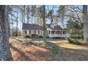 Traditional home with a covered front porch, set amid mature trees and lush greenery, offering great curb appeal at 3281 Old Salem Rd, Conyers, GA 30013