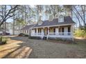 Inviting single-Gathering home featuring a classic design with a full, covered front porch and a neatly maintained yard at 3281 Old Salem Rd, Conyers, GA 30013