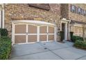 Attached garage with stylish white and brown door, complemented by manicured landscaping at 971 Thibideau Ct, Sandy Springs, GA 30328