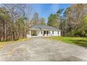 A single-story white home with a convenient carport surrounded by trees at 2374 Buchanan Hwy, Dallas, GA 30157