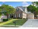 Two-story home features a well-manicured lawn, a driveway leading to a two-car garage, and mature landscaping at 4126 Gold Mill Rdg, Canton, GA 30114