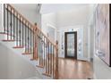 Spacious foyer with hardwood floors, staircase with iron railings, and decorative glass front door at 4126 Gold Mill Rdg, Canton, GA 30114