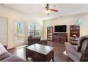 Comfortable living room with hardwood floors, a ceiling fan, and natural light streaming through the windows at 307 Montgomery Way, Woodstock, GA 30188