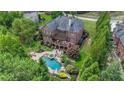 Backyard featuring a large pool, spa, and an outdoor seating area with lush landscaping at 1391 Harris Rd, Lawrenceville, GA 30043