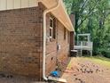 Exterior side view of a brick house, showing a deck in a backyard surrounded by green trees at 213 Sharon Drive, Canton, GA 30115
