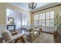 Bright sitting room featuring elegant chandelier, plantation shutters and neutral decor at 4022 Newhaven Ne Cir, Brookhaven, GA 30319