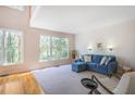 Sunlit living room with large windows, hardwood floors, neutral carpeting, and comfortable blue seating at 1926 Regency Cove Ct, Atlanta, GA 30341