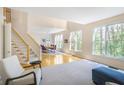 Spacious living room with hardwood floors, bright windows, and adjacent dining area with modern lighting fixtures at 1926 Regency Cove Ct, Atlanta, GA 30341
