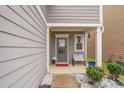 Welcoming covered front porch with a bench, gray door, and small plants, inviting relaxation at 3200 Baylor Cir, Mcdonough, GA 30253