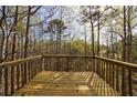 View of the wooded backyard from the home's wooden deck, perfect for relaxing outdoors at 6490 Lake Esther Dr, Fairburn, GA 30213