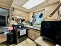 Compact kitchen with stainless steel appliances, wooden cabinetry, and sink at 6917 Laurelwood Dr, Douglasville, GA 30135