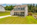Attractive two-story home with a green lawn and inviting covered front porch at 1661 Flagstone Ln, Conyers, GA 30012