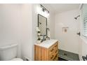 Modern bathroom featuring a wooden vanity, a quartz countertop, and a walk-in shower with black fixtures at 1048 Pinehurst Se Dr, Smyrna, GA 30080
