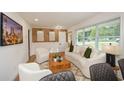 Bright living room with large windows, stylish furniture, wood accent wall, and a decorative fireplace at 1048 Pinehurst Se Dr, Smyrna, GA 30080