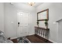 Welcoming entryway with dark wood floors, console table, mirror, and white front door at 1310 Roger Trace, Lithonia, GA 30058