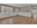 Bright living room with wood-look floors, white wainscoting, and large windows at 272 Colchester Dr, Stone Mountain, GA 30088
