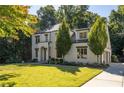 A charming two-story home with lush greenery, mature trees, and a manicured lawn creating an inviting curb appeal at 515 Danube Ne Rd, Atlanta, GA 30342