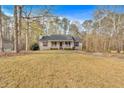View of a single-story home with a sprawling front lawn, mature trees, and a quaint front porch at 4565 Canebrake Ct, Powder Springs, GA 30127
